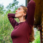 Casual style with women's burgundy ribbed top outside of a cabin