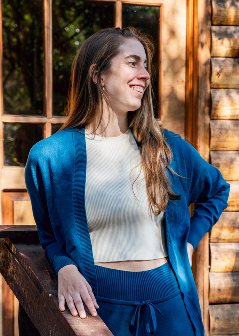 Women's Camille Ribbed Crop Top in an ivory color shown with the blue Callie Front Ties Sweater on a woman in front of a cabin