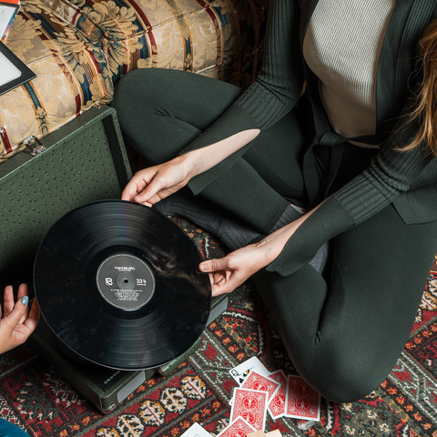 Woman lounging with a record player wearing no drawstring jogger pants in green with matching green sweater