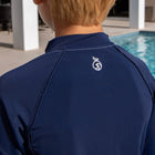 Back of Boy by the pool wearing a blue long sleeve rash guard designed for swimming