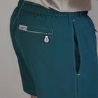 Closeup of the the side of a man from the waist down wearing green shorts