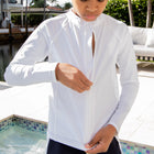 Closeup of a boy in a pool zipping up his swim shirt