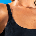 Close up of a womans shoulder to show the fabric of her bikini top