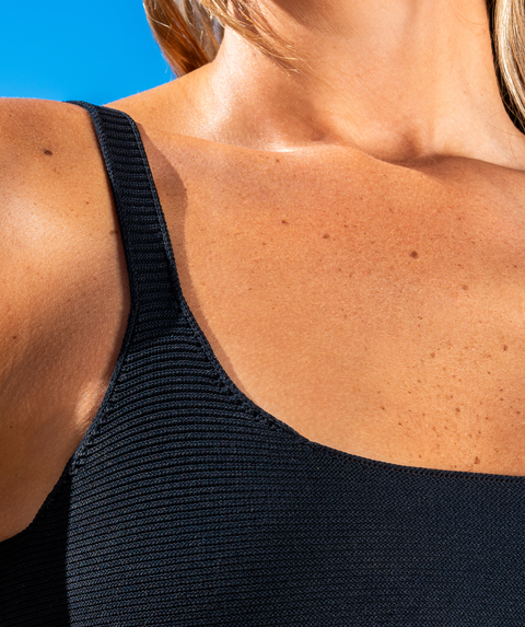 Close up of a womans shoulder to show the fabric of her bikini top