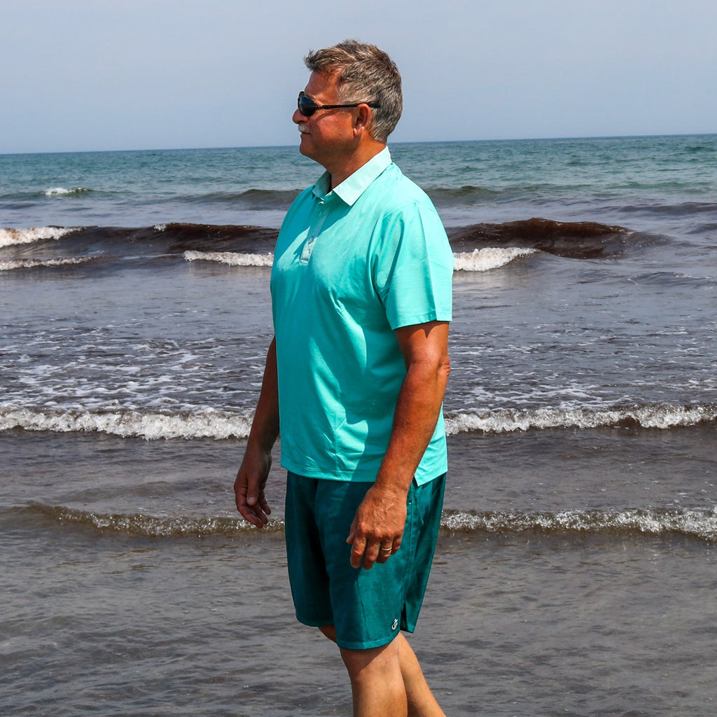 Model in a green NoNetz polo  and Men's Haven Regular Fit 8" Inseam Swim Trunks on the beach