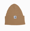Beige knit beanie with a logo tag on a white background
