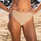 Lower half of woman in a tan bikini on the beach fashion and sustainability