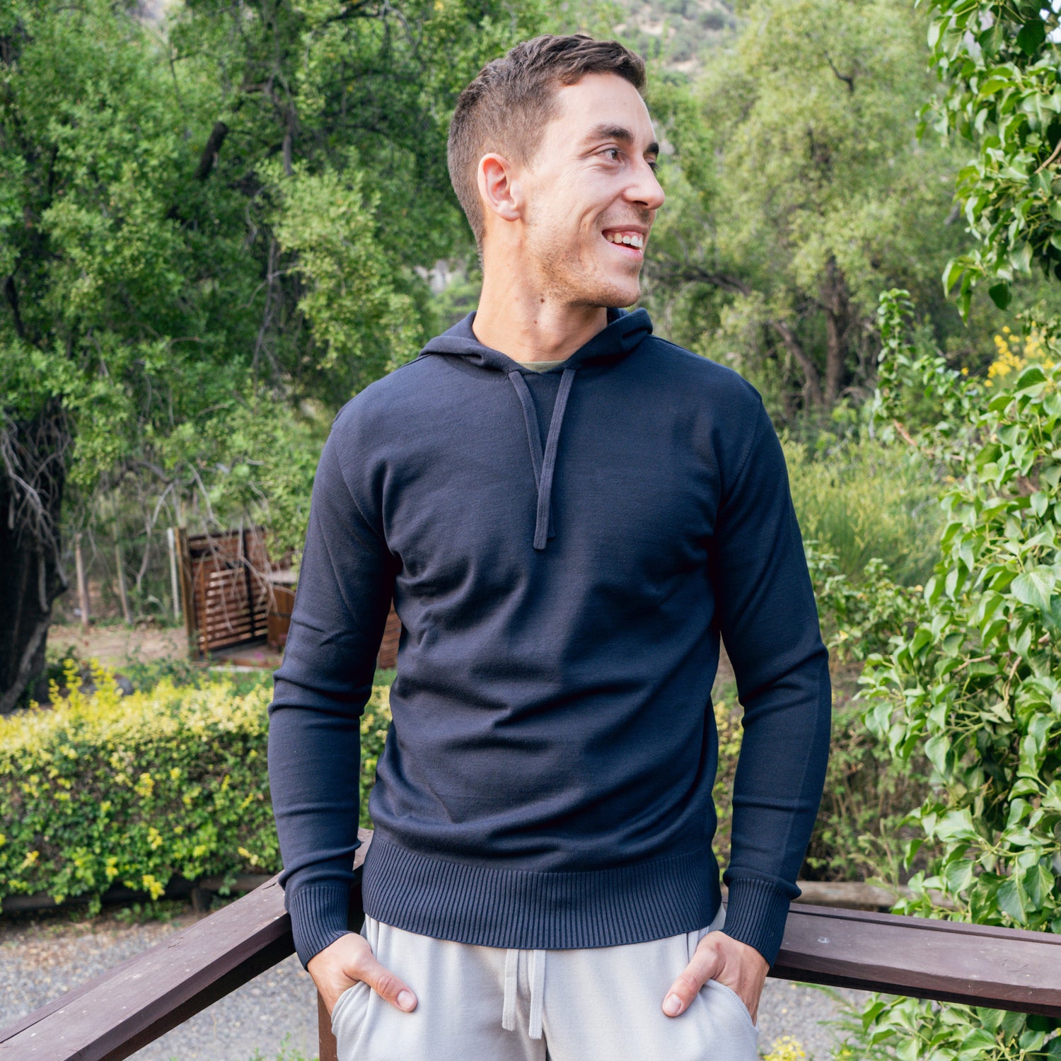 Man in navy blue hoody leaning against a rail