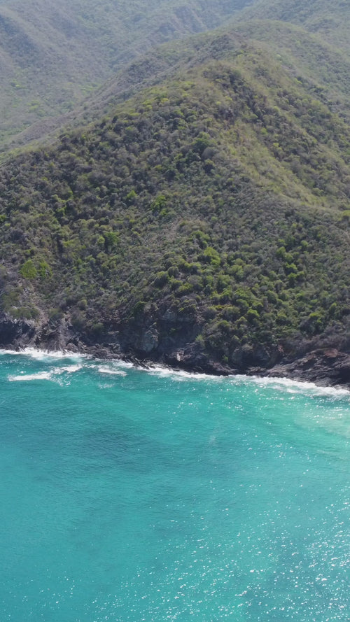 drone footage of an island shoreline and jungle